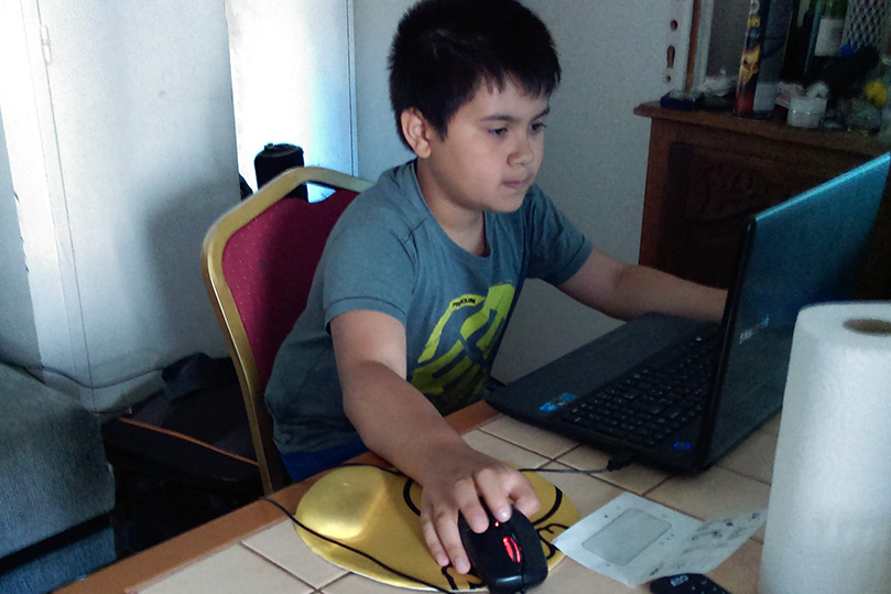 Christian Phienboupha à 7 ans devant son ordinateur.