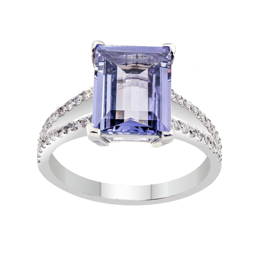 Bague en or blanc sertie d'un saphir bleu et de diamants sur un fond blanc