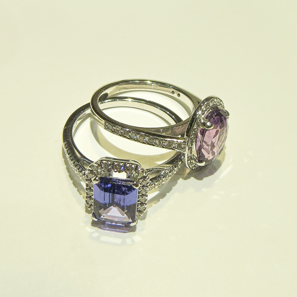 Bagues en or blanc serties d’un saphir bleu et d’une topaze rose avec pavage de diamants, bijoux précieux élégants et modernes.