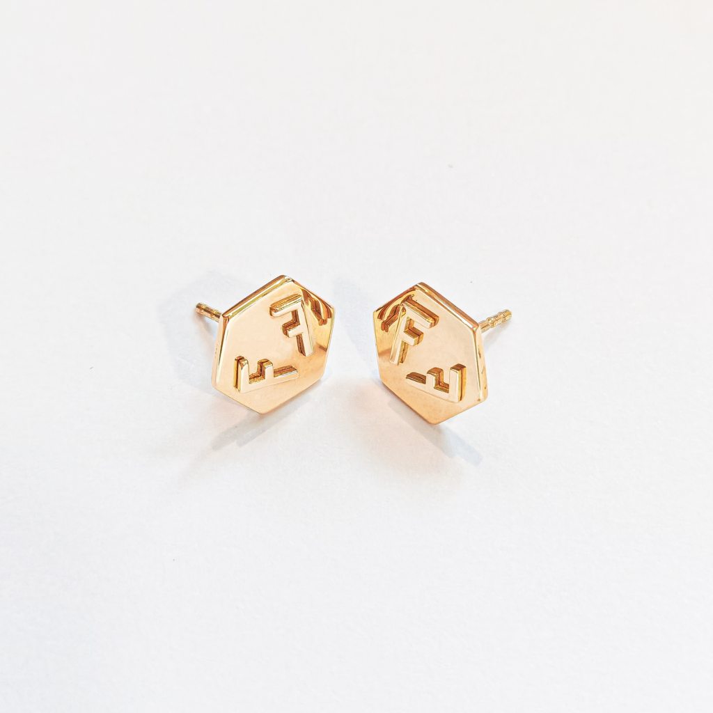 Paire de boucles d'oreilles en or jaune 18 carats sur un fond blanc